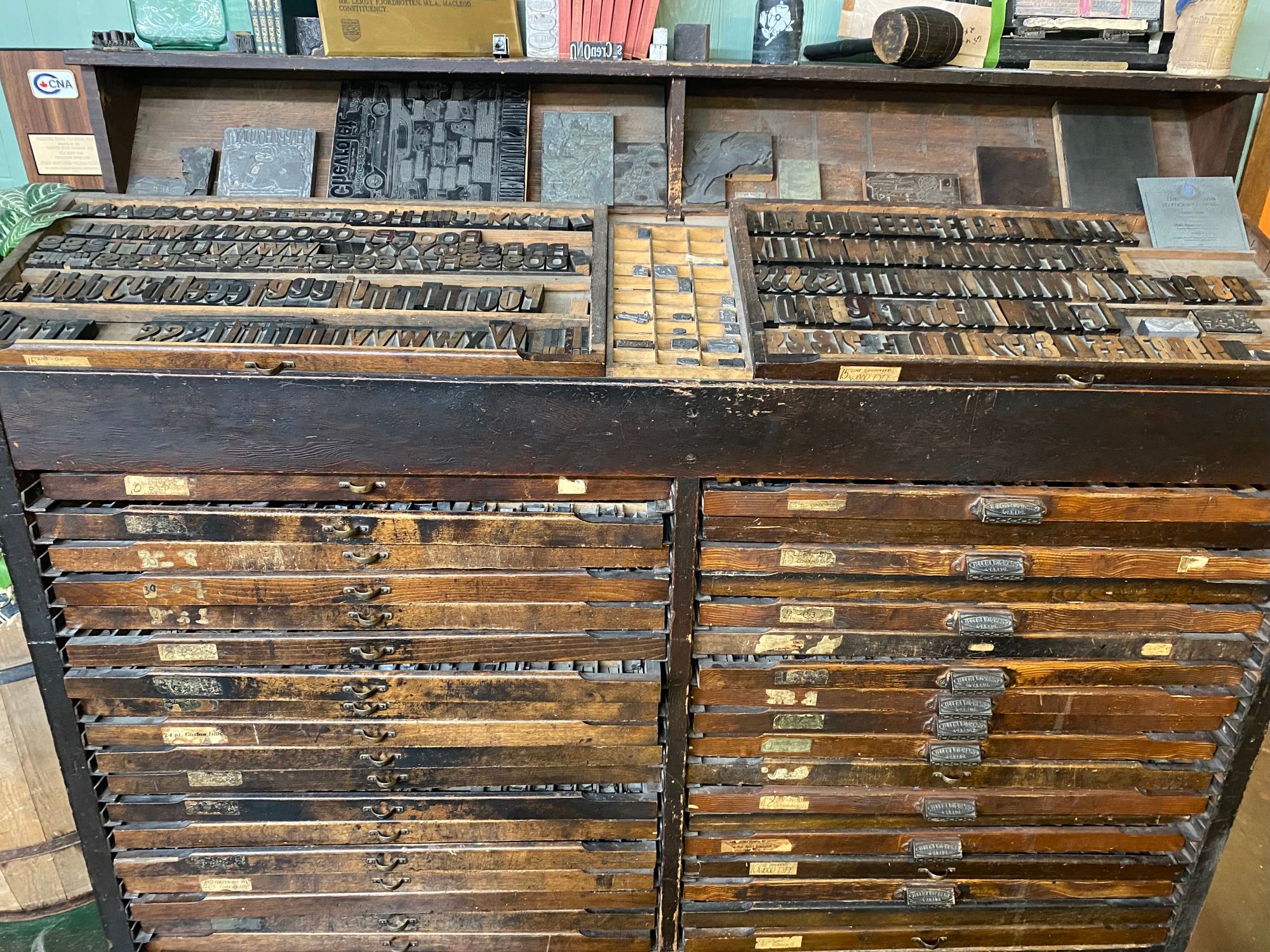 Image: A newspaper printing cabinet that contains metal letters for a printing press.